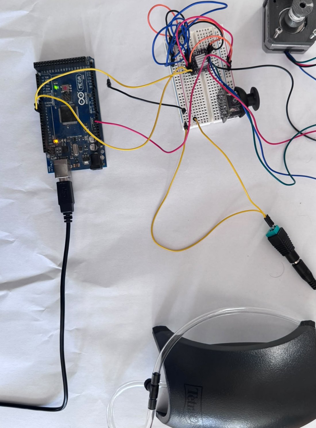 Control prototype on white paper: Arduino Mega, breadboard with stepper driver, stepper motor with cable winch and an air pump